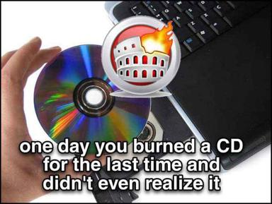 A hand holds a CD as a magnifying glass reveals the burning Colosseum — a nostalgic meme about obsolete media and forgotten last moments.