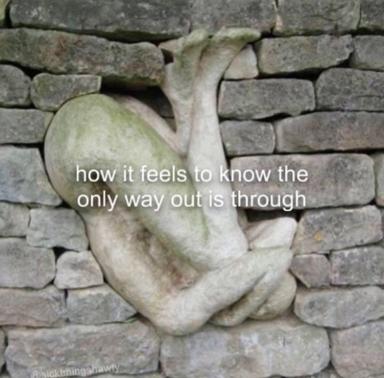 A stone gargoyle twisted between brick courses: an architectural metaphor for inescapable despair.